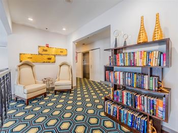 A room with a patterned carpet and a bookshelf filled with books.